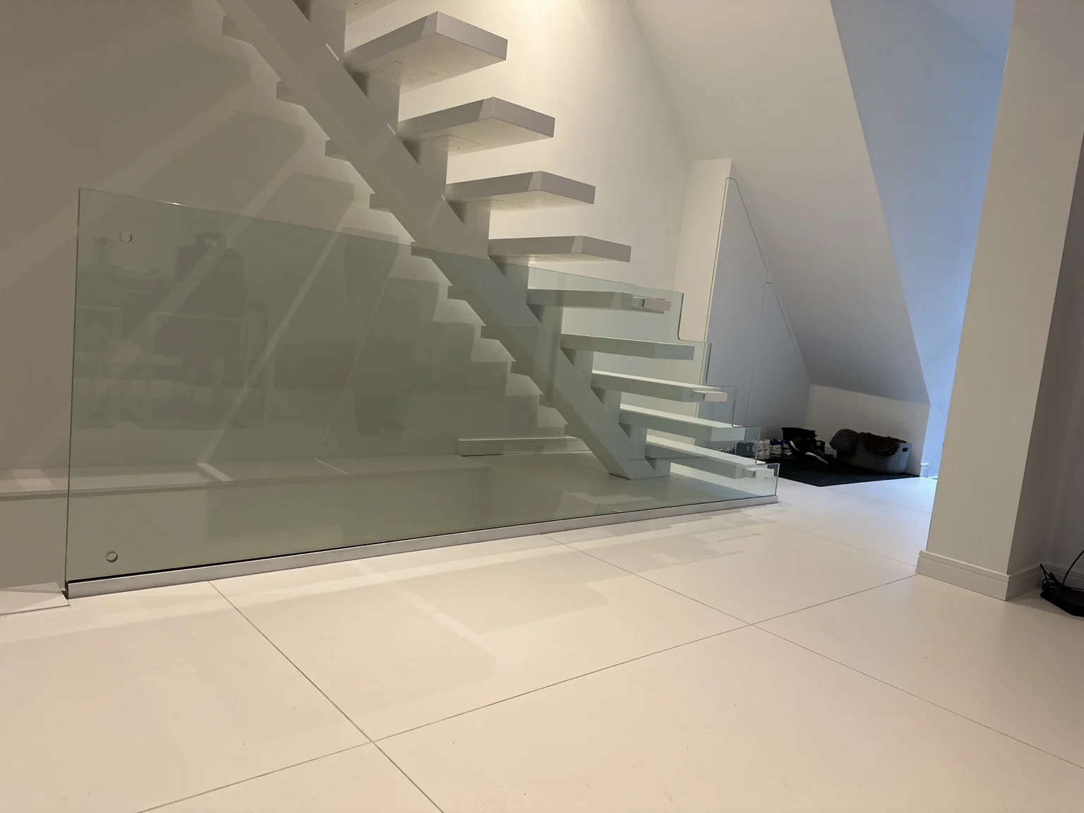 Witte open trap met een glazen balustrade op maat