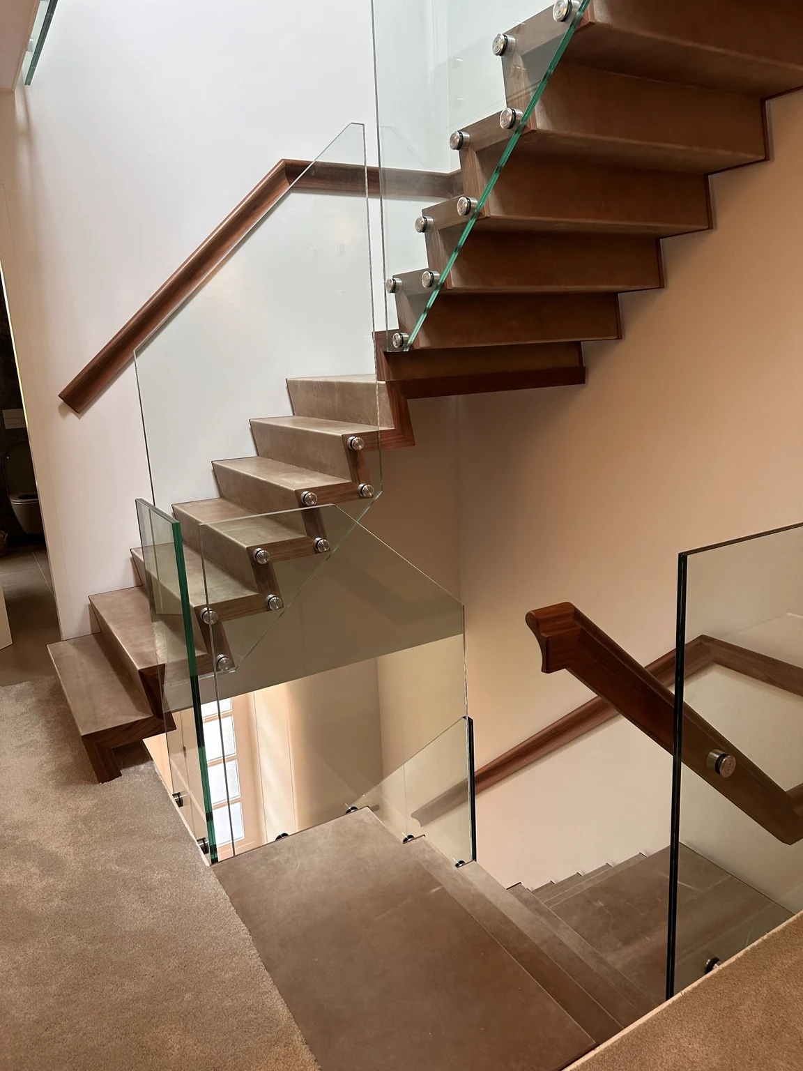 Glazen balustrade langs een houten trap