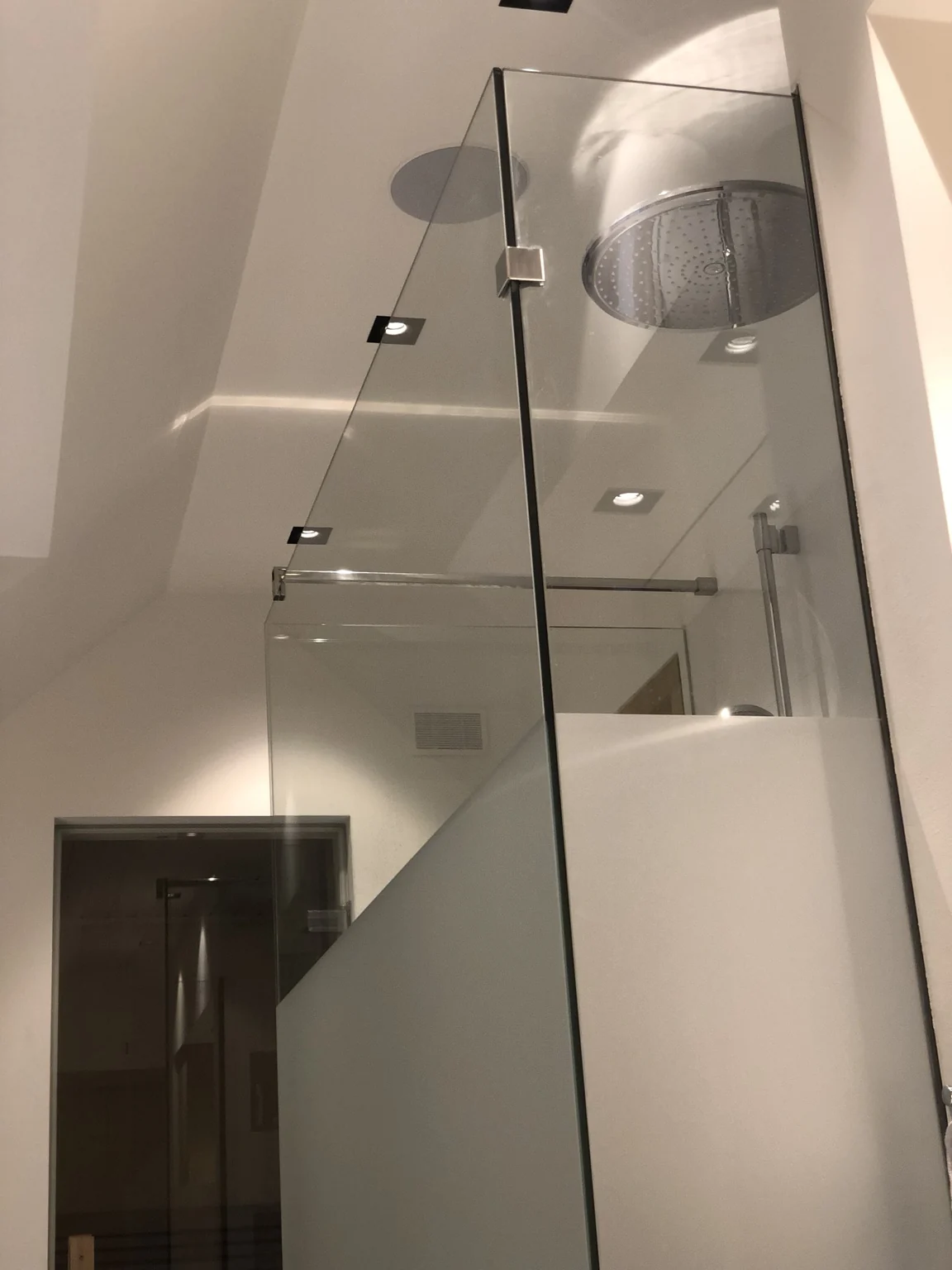 Hoge glazen douchewand met een deels matte afwerking