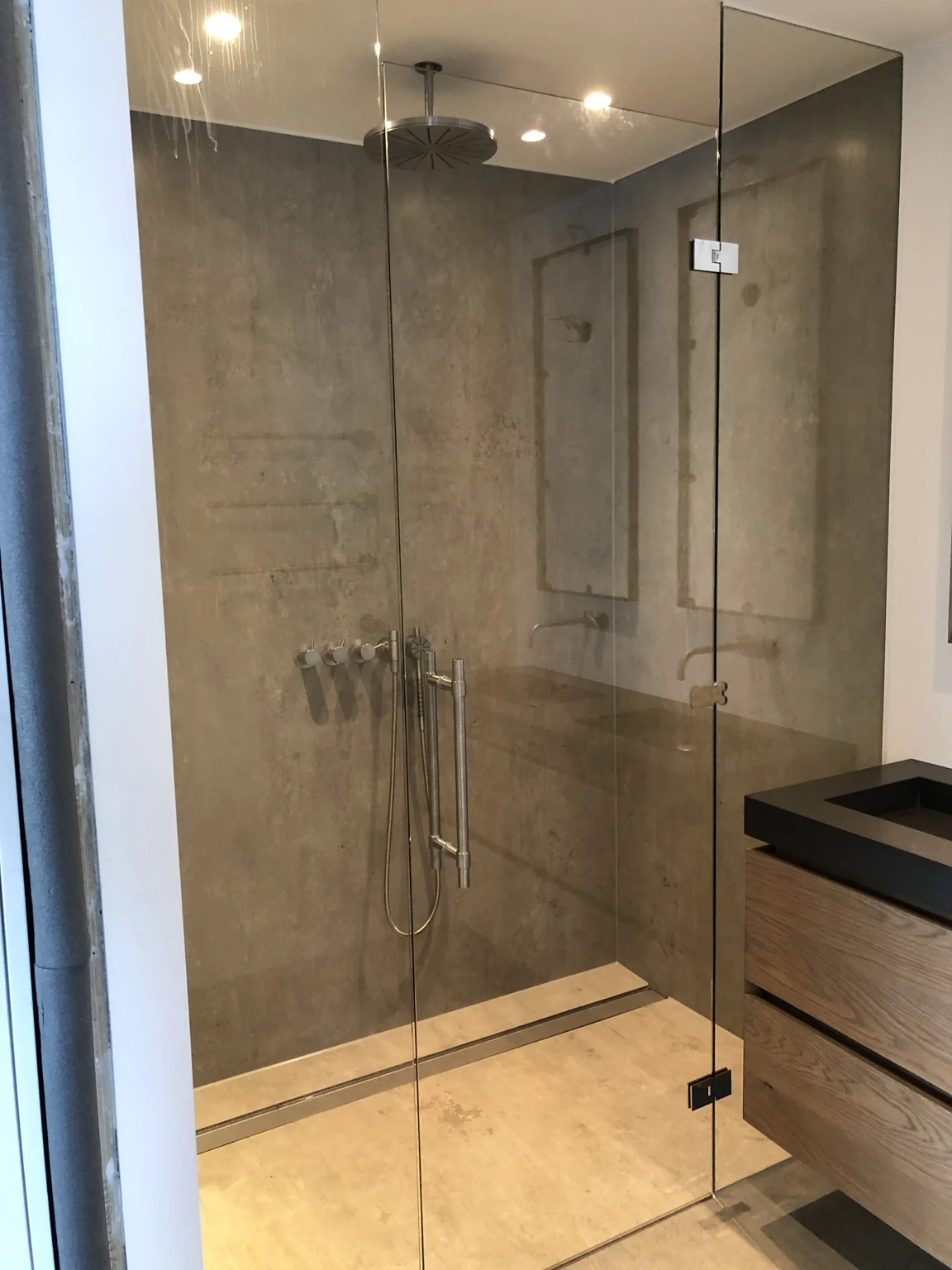 Glazen douchedeur in een badkamer met warme tinten