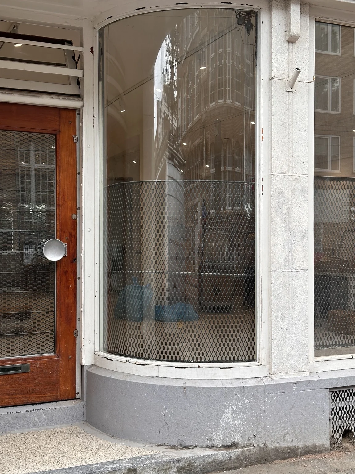 Gebogen beglazing naast een entree in een bestaande gevel