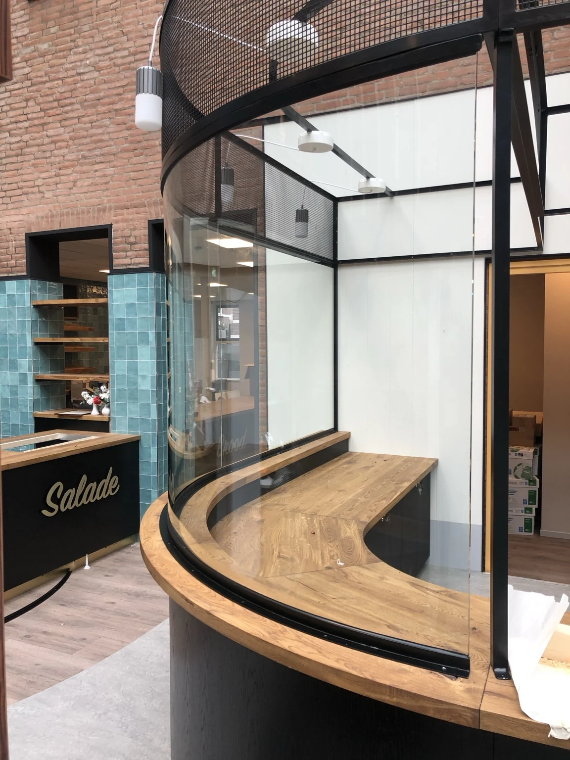 Gebogen glazen wand langs een ronde houten balie