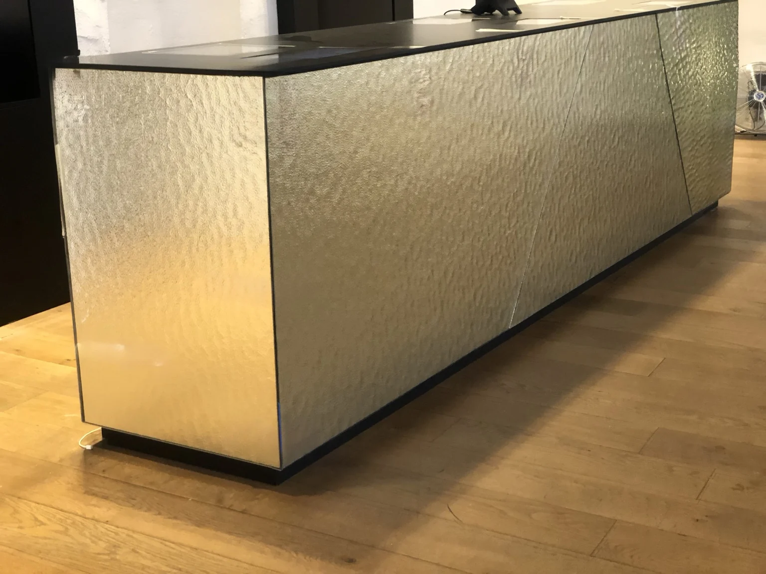 Detail van spiegelpanelen met een reliëfstructuur aan een balie